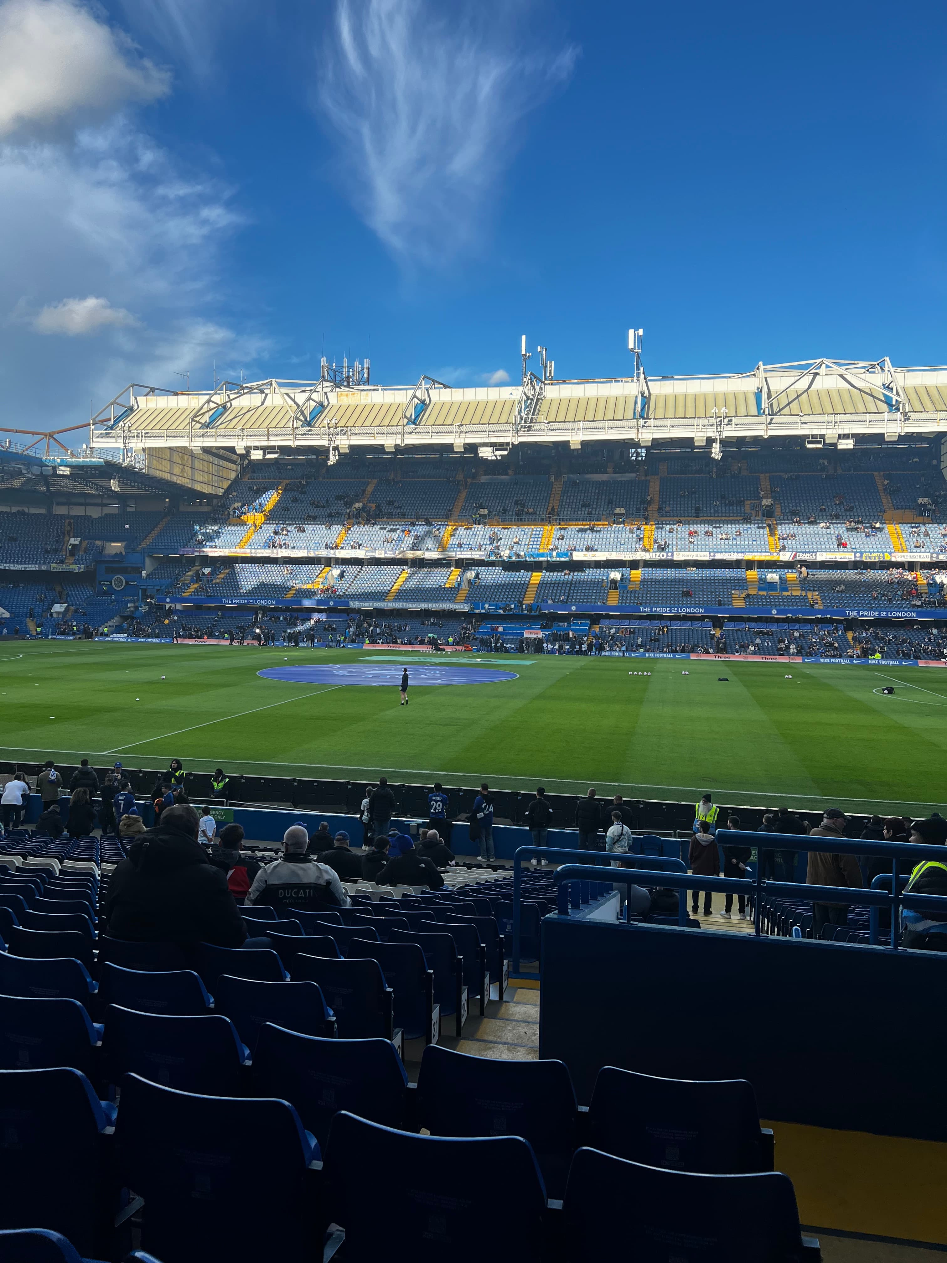Stamford Bridge inside view Chelsea FC pitch and stands Pride of London banners blue seats Premier League matchday
